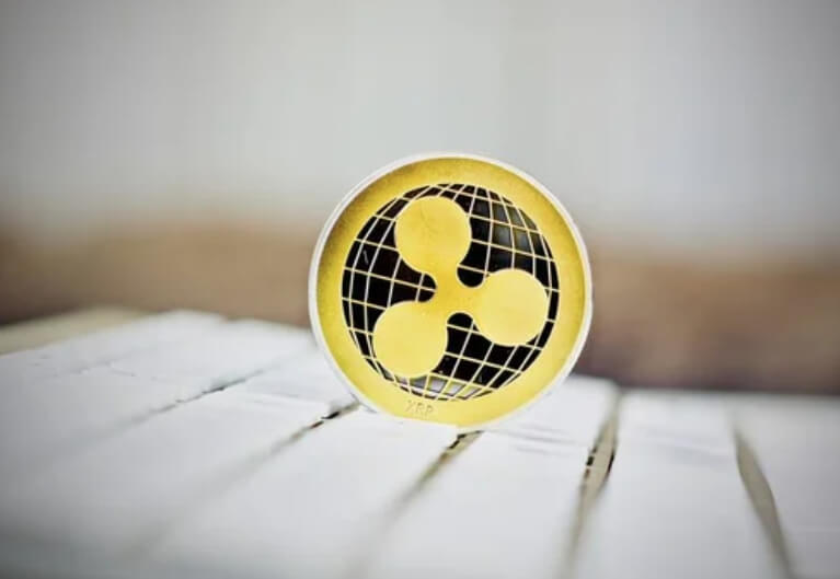 XRP “super cycle” chatter faces a weekly SuperTrend sell signal, with XRP down 2% to $2.07 over the past week even as broader crypto markets tick higher.